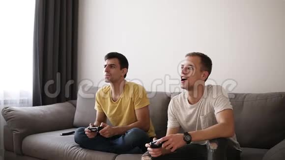 两个游戏玩家在玩完游戏后坐在沙发上其中一个是胜利者享受着那种感觉视频的预览图