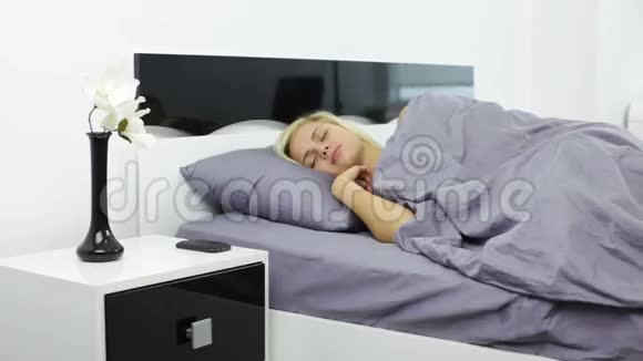 女士关掉闹钟躺在床上视频的预览图