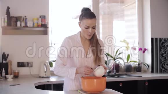 在宽敞的厨房里可以看到漂亮女人做饭的前景视频的预览图