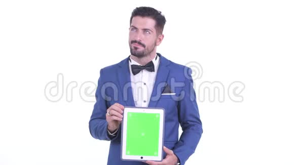 年轻有胡子的快乐商人在展示数码平板电脑视频的预览图