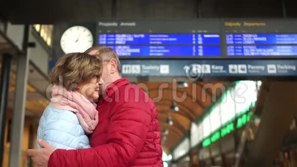 可爱的夫妇在火车站拥抱一男一女抱在火车站站台上抚摸视频的预览图