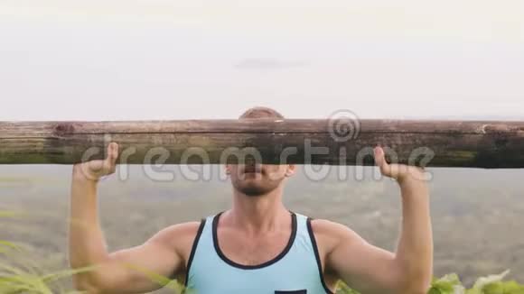热带山地用木杠铃进行强壮的男子训练练习健美男子举重视频的预览图