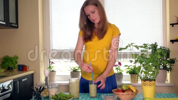 美丽的孕妇喝新鲜水果和牛奶鸡尾酒并在镜头前微笑视频的预览图
