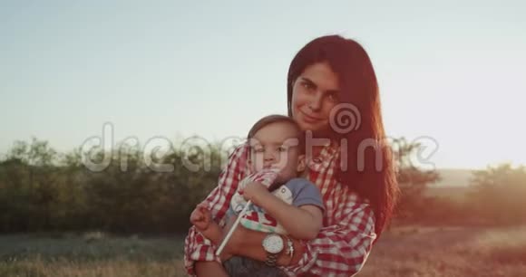 特写一位妈妈带着儿子在镜头前有一个大大的微笑心情愉快抱着她的宝贝这么可爱视频的预览图