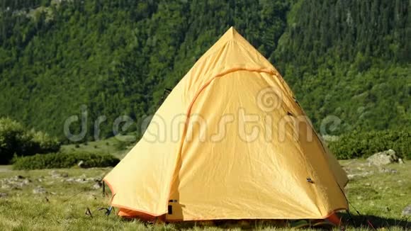 昏昏欲睡的旅游妇女打开帐篷早上在营地的一座高山的背景下向外看视频的预览图