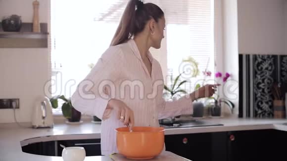 在宽敞的厨房里可以看到漂亮女人做饭的前景视频的预览图