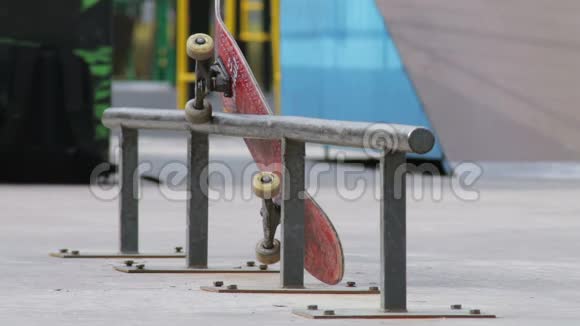 溜冰者拿着滑板在斯劳德摩公园的铁轨上试着玩视频的预览图