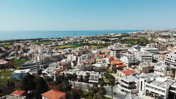 无人机在塞浦路斯城市帕福斯上空飞行背景是屋顶和海洋空中射击视频的预览图