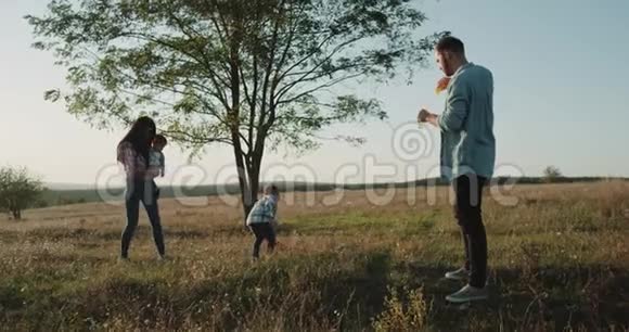 四个家庭成员在大自然中度过了完美的时光两个小男孩在阳光明媚的夏天制作泡泡4k视频的预览图