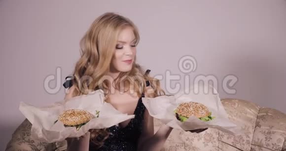 两个女朋友在吃汉堡包两个女人吃着美味的汉堡视频的预览图
