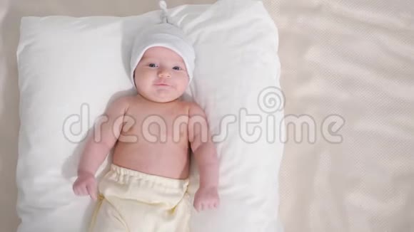 戴着帽子和裤子的可爱宝宝在灰色背景下微笑视频的预览图