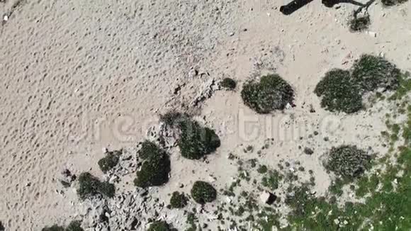 空中顶部拍摄的沙滩与塑料垃圾瓶肮脏的沙质岩石海滩有塑料瓶和一堆垃圾视频的预览图