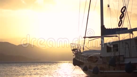 日落时分在山间海上缓慢停泊的大船视频的预览图