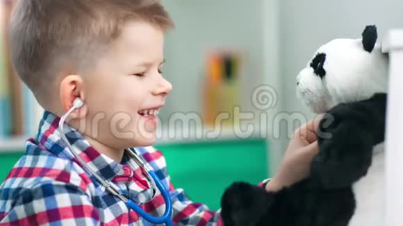 可爱的男孩正在用听诊器和他的软玩具玩医生视频的预览图