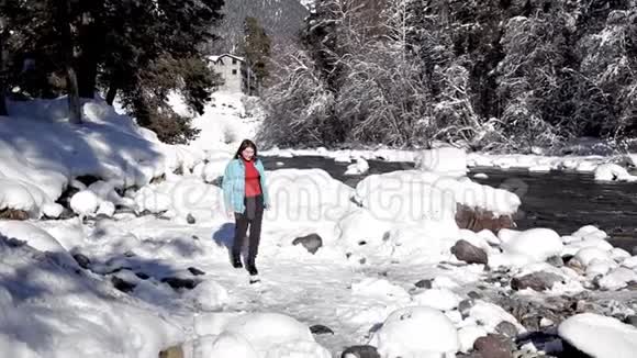 五彩缤纷的冬季景观一个女孩沿着一个山湖散步晶莹剔透的田园冬季美景视频的预览图