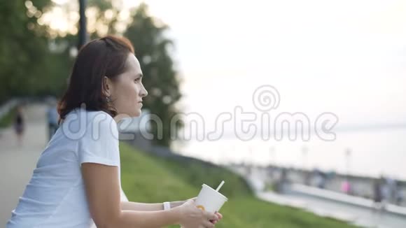 一个穿着白色T恤的女人在海滨欣赏美丽的景色视频的预览图