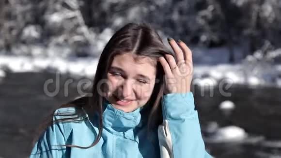 冬天在河边和圣诞树旁微笑的年轻女子视频的预览图