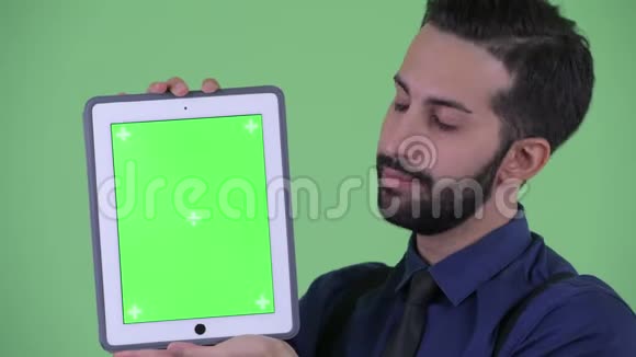 快乐的长着胡须的波斯商人展示数码平板电脑视频的预览图