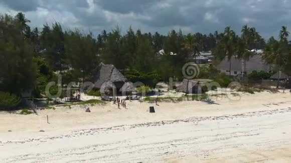 Drone沿着蓝绿色的海洋海岸在异国情调的桑给巴尔岛上扩建豪华平房视频的预览图