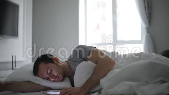 躺在床上拿着手机的男人视频的预览图