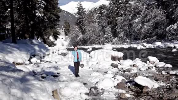 五彩缤纷的冬季景观一个女孩沿着一个山湖散步晶莹剔透的田园冬季美景视频的预览图