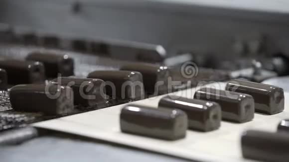 生产巧克力的生产线巧克力覆盖的糖果糖果沿着传送带移动视频的预览图