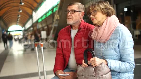 一对年长的男人和女人在等他的火车离开听说着陆的消息就去了视频的预览图