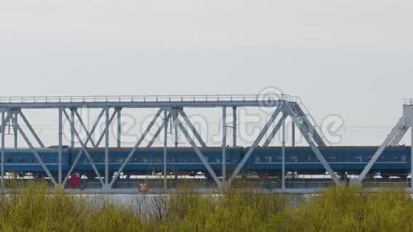 乘用车蓝色的火车穿过大桥金属支撑顶着天空视频的预览图