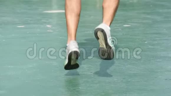 穿着运动鞋的男士的腿在绿色的背景下平稳地慢跑视频的预览图