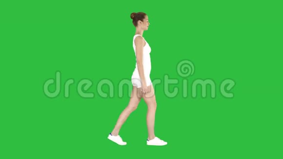 穿着运动服的年轻女子在绿色屏幕上散步用彩色键视频的预览图