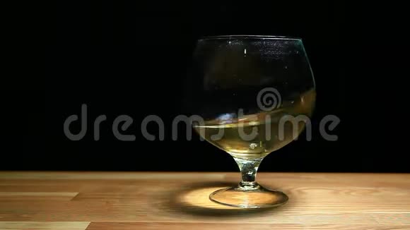 白色酒杯木制桌子深色背景无人高清镜头视频的预览图