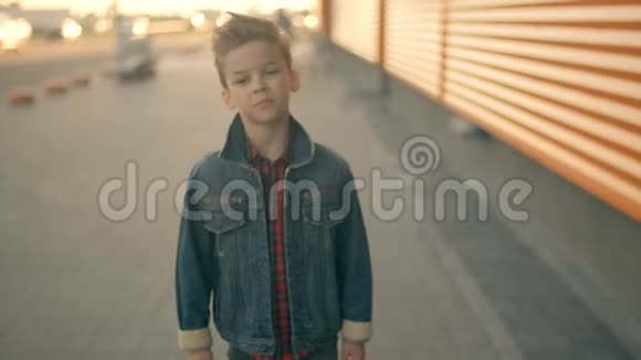 悲伤的男孩走在街上思考一个严肃悲伤的小男孩的脸肖像视频的预览图
