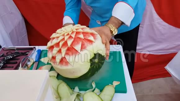 厨师在新鲜西瓜上切花装饰装饰西瓜雕刻视频的预览图