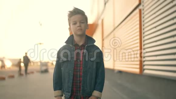 独自一人的小男孩走在街上思考一个严肃悲伤的男孩的脸视频的预览图