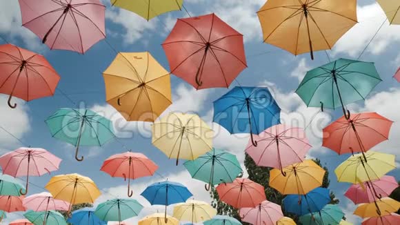 蓝色天空背景上的多色雨伞视频的预览图