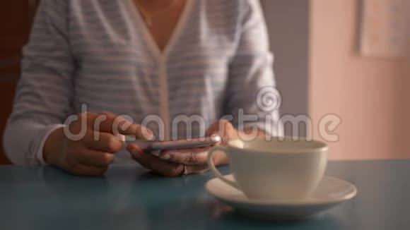 女商人在办公桌上用智能手机喝了一杯咖啡视频的预览图