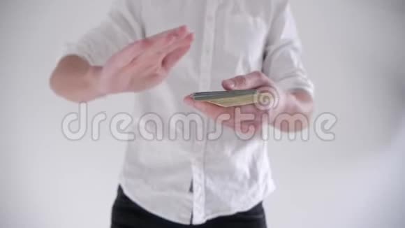 快乐男人在白色背景上扔钱慢动作视频的预览图