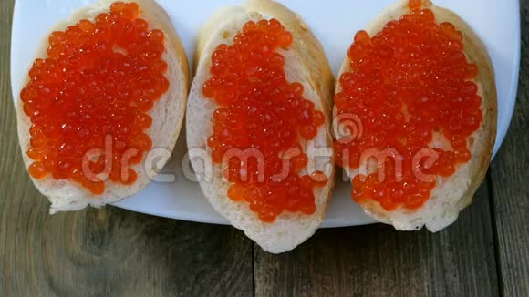 用红鱼子酱准备三明治红鱼子酱用菜刀涂抹在一片白面包上视频的预览图