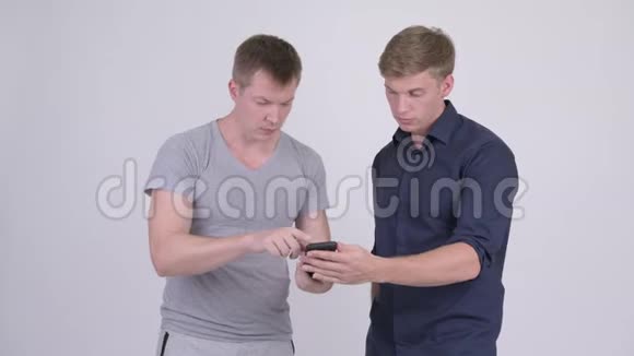 两个快乐的年轻人用电话一起得到好消息视频的预览图