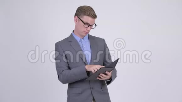 年轻英俊的商人一边用眼镜看书一边思考视频的预览图