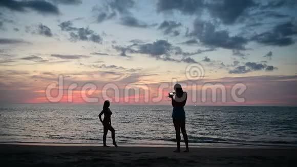 K4年轻女孩喜欢海滩上的海景还可以打电话给其他女孩拍照视频的预览图