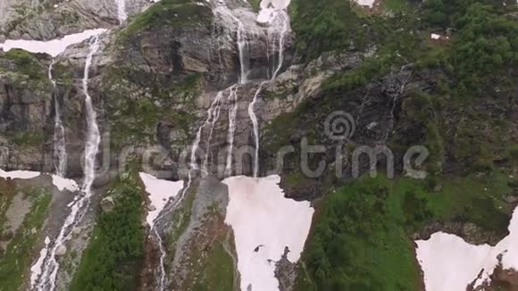 空中观景无人机拍摄到几条瀑布从陡峭的大山岩上流下来这些岩石被郁郁葱葱地包围着视频的预览图