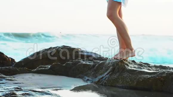 女人走在沙滩上有大石头腿特写视频的预览图