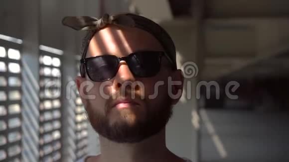 特写一幅戴着太阳镜站在大门附近的蓄胡子男子的画像视频的预览图