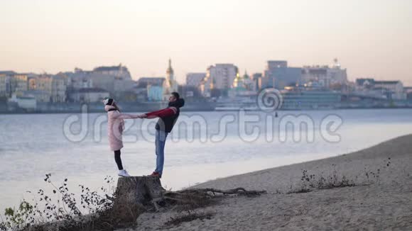 爱的年轻夫妇在秋天在海滩上享受大自然笑拥抱4K慢莫视频的预览图