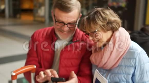 夫妻在笑看着智能手机里的照片一对幸福成熟的夫妇的亲密画像视频的预览图