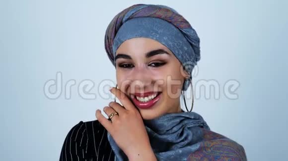 年轻美丽的阿拉伯女人微笑着用手触摸她的脸用她孤立的白色背景视频的预览图
