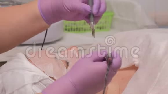 戴紫丁香手套的美容师开始使用电极使手术效果恢复活力妇女视频的预览图