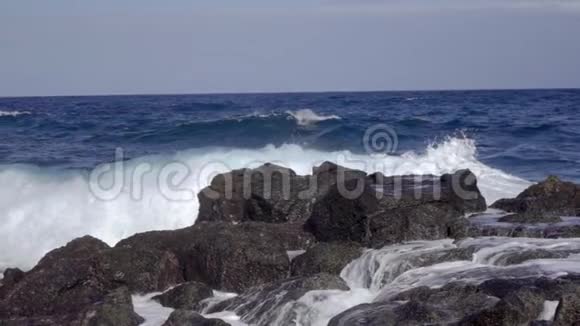 海浪在岩石海岸的石头上溅起缓慢的浪花视频的预览图