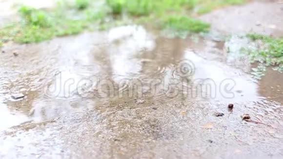 雨水滴在沥青上的水池上夏季多云天气视频的预览图